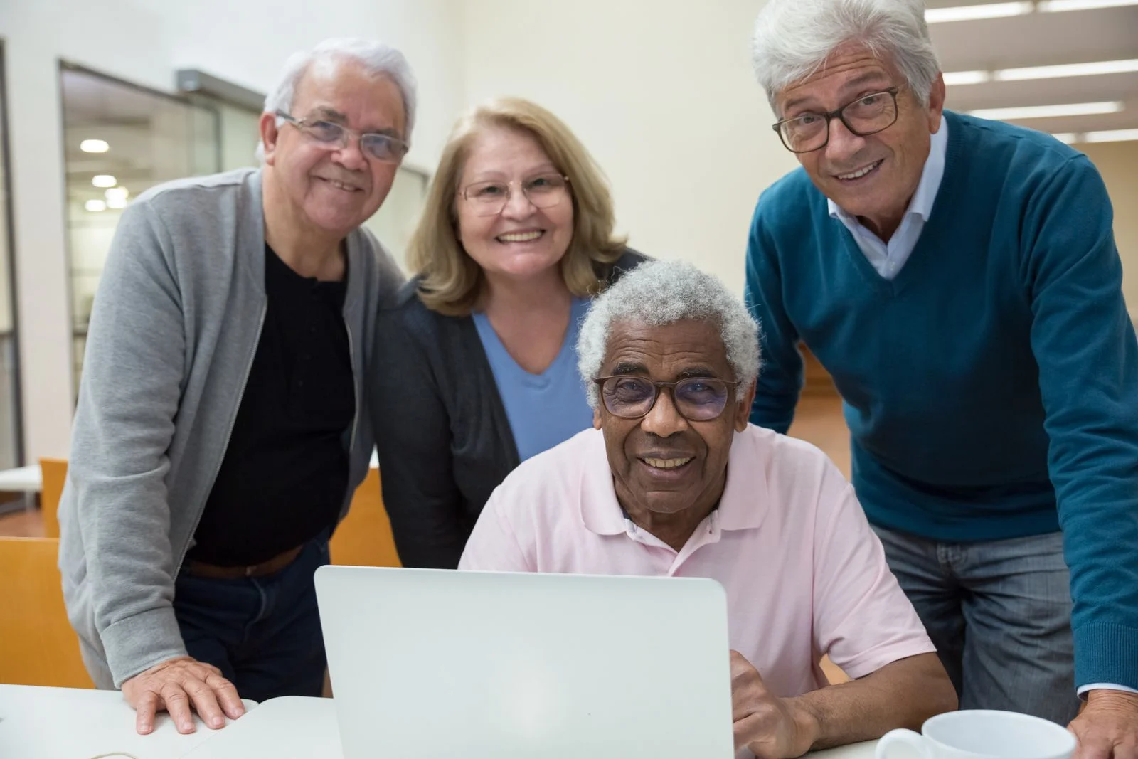 Older adults learning digital skills together around a laptop